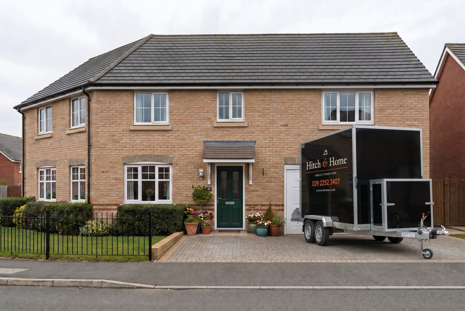 Hitch and Home trailer outside a modern stone-fronted house